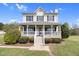 Lovely two-story house with a charming front porch, white railings, and decorative wreath at 2651 Bennett Rd, Creedmoor, NC 27522