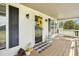 Close up of the front porch featuring a storm door adorned with a wreath, lanterns, and a cozy porch swing at 2651 Bennett Rd, Creedmoor, NC 27522