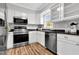 Modern kitchen with stainless steel appliances, granite countertops, and bright white cabinetry at 2651 Bennett Rd, Creedmoor, NC 27522