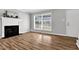 Bright living room with hardwood flooring, a fireplace, a large window, and fresh paint at 2651 Bennett Rd, Creedmoor, NC 27522