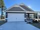 This is an exterior shot of a charming one-story home, complete with a two car garage and stone accents at 291 Deodora Ln, Cameron, NC 28326