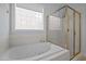 Bathroom featuring a jetted tub, a glass shower, and a window providing natural light at 30079 Britt, Chapel Hill, NC 27514