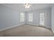 Bedroom featuring neutral colored carpet, two windows and a door at 30079 Britt, Chapel Hill, NC 27514