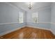Bright bedroom with hardwood floors, chandelier lighting, and ample natural light at 30079 Britt, Chapel Hill, NC 27514