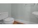 Powder room featuring white fixtures, wood flooring, and light green walls at 306 Perry St, Raleigh, NC 27608