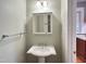 Bathroom featuring white pedestal sink, mirrored vanity, and modern lighting at 306 Perry St, Raleigh, NC 27608