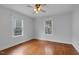 Bedroom with hardwood floors, ceiling fan, and natural light from two windows at 306 Perry St, Raleigh, NC 27608