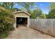 The open door of a detached garage shows space for parking, surrounded by greenery and a fence at 306 Perry St, Raleigh, NC 27608