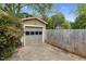 A detached garage featuring a gray door surrounded by lush greenery and a wooden fence at 306 Perry St, Raleigh, NC 27608