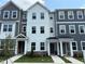 Attractive exterior elevation showcasing three-story townhomes with contemporary gray and white siding and stone accents at 331 Deercroft Dr, Apex, NC 27539