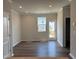 Living room showcasing neutral decor with new flooring, leading to an exterior patio door at 331 Deercroft Dr, Apex, NC 27539