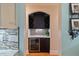 Stylish bar area featuring a wine refrigerator, custom cabinetry, and granite countertops at 36 Wellspring Cir, Clayton, NC 27527
