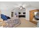 A well-lit carpeted bedroom with a ceiling fan, an armoire, and a wet bar area featuring dark cabinetry at 36 Wellspring Cir, Clayton, NC 27527