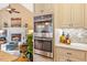 Modern kitchen with stainless steel oven and granite countertops, accompanied by a fireplace and living area at 36 Wellspring Cir, Clayton, NC 27527