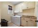 Laundry room with upper cabinets, a utility sink, a window, and a washer and dryer hook up at 36 Wellspring Cir, Clayton, NC 27527