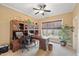 Cozy home office featuring a wooden desk, custom built-ins, a ceiling fan and a sun-filled window at 36 Wellspring Cir, Clayton, NC 27527