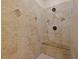 Luxurious shower with stone-patterned tile, a built-in bench, and dual shower heads, showcasing a spa-like experience at 36 Wellspring Cir, Clayton, NC 27527