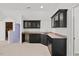Stylish wet bar features sleek black cabinets, ample counter space, and convenient access to a nearby room at 36 Wellspring Cir, Clayton, NC 27527