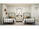 Shared bedroom with two beds and a central dresser featuring minimalist artwork and lamps at 4016 Shadbush St, Raleigh, NC 27616