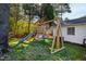 A backyard view reveals a wooden playset with a slide and swings, set against a backdrop of trees at 508 Currituck Dr, Raleigh, NC 27609