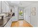Charming kitchen features white cabinets, stainless appliances, hardwood floors, and glass door to back patio at 508 Currituck Dr, Raleigh, NC 27609