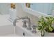 Close-up of a bathroom sink featuring modern fixtures and a plant for decor at 510 Glenwood Ave # 602, Raleigh, NC 27603