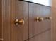 Close up of a modern vanity featuring wood panels and round gold hardware at 510 Glenwood Ave # 602, Raleigh, NC 27603