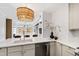 Bright kitchen features a quartz countertop island, stainless appliances and stylish chandelier at 510 Glenwood Ave # 602, Raleigh, NC 27603