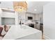 Modern kitchen features a quartz countertop island, stainless appliances, and a stylish chandelier at 510 Glenwood Ave # 602, Raleigh, NC 27603