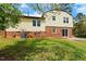The back exterior features a brick foundation, sliding glass doors and a well-maintained lawn at 5401 Kaplan Dr, Raleigh, NC 27606