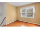 Bedroom with wood floors, one window, and light yellow walls at 5401 Kaplan Dr, Raleigh, NC 27606