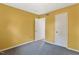 Bedroom features yellow walls, carpeted floor, and a door to the adjoining room at 5401 Kaplan Dr, Raleigh, NC 27606