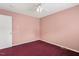 Cozy bedroom features pink walls, a ceiling fan, and plush carpeting at 5401 Kaplan Dr, Raleigh, NC 27606