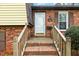 Close-up of a brick home's entrance, showcasing a white door with house number and a small porch with wooden railings at 5401 Kaplan Dr, Raleigh, NC 27606