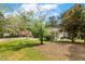 Front yard features mature trees, lush grass, and a carport at 5401 Kaplan Dr, Raleigh, NC 27606