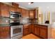 Well lit kitchen with stainless steel appliances, wood cabinets, and black countertop at 5401 Kaplan Dr, Raleigh, NC 27606