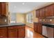 Bright kitchen with stainless steel dishwasher, wood cabinets, and wood floor at 5401 Kaplan Dr, Raleigh, NC 27606