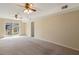 Spacious living area with neutral carpet, sliding glass door, and ceiling fan lighting at 5401 Kaplan Dr, Raleigh, NC 27606