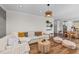 Open-concept living room featuring modern decor, wood floors, and a view into the dining and kitchen areas at 6 S Summerhill Rdg, Clayton, NC 27520