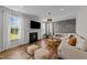 Comfortable living room with a fireplace, large windows, wood floors, and modern decor at 6 S Summerhill Rdg, Clayton, NC 27520