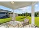 Cozy covered patio with comfortable seating and a view of the landscaped backyard at 6 S Summerhill Rdg, Clayton, NC 27520