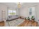 Bright sitting room with large windows, hardwood floors, and a neutral-colored sofa at 6 S Summerhill Rdg, Clayton, NC 27520