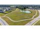 Aerial view of neighborhood walking path around large field and pond at 6 S Summerhill Rdg, Clayton, NC 27520