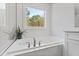 Clean, white bathroom features an elegant soaking tub with large window at 609 Meyers Place Ln, Holly Springs, NC 27540