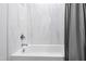 Bright bathroom with a tiled shower and tub combination with a gray shower curtain at 609 Meyers Place Ln, Holly Springs, NC 27540