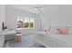 Bright bedroom featuring large window, desk area, and white furnishings creating a cheerful and inviting space at 609 Meyers Place Ln, Holly Springs, NC 27540