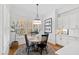 Cozy dining area with a view of the modern kitchen, featuring hardwood floors and natural light at 609 Meyers Place Ln, Holly Springs, NC 27540