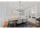 Elegant dining room with hardwood floors, large windows, modern chandelier, and stylish furniture for entertaining at 609 Meyers Place Ln, Holly Springs, NC 27540