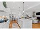 Bright, white kitchen with a large island, stainless appliances, hardwood floors, and an open floor plan at 609 Meyers Place Ln, Holly Springs, NC 27540