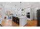 Well-appointed kitchen with white cabinetry, an island with seating, modern appliances, and an adjacent dining area at 609 Meyers Place Ln, Holly Springs, NC 27540